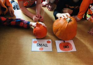 Dzieci trzymają dynię wskazując na dużą (big) i mała (small).